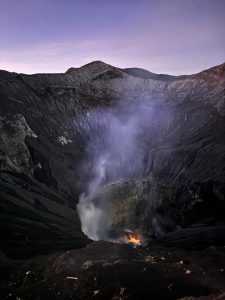 red glowing lava inside Mount Bromo crater viewed from the crater rim at night